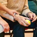 woman holding man's hand in a care home