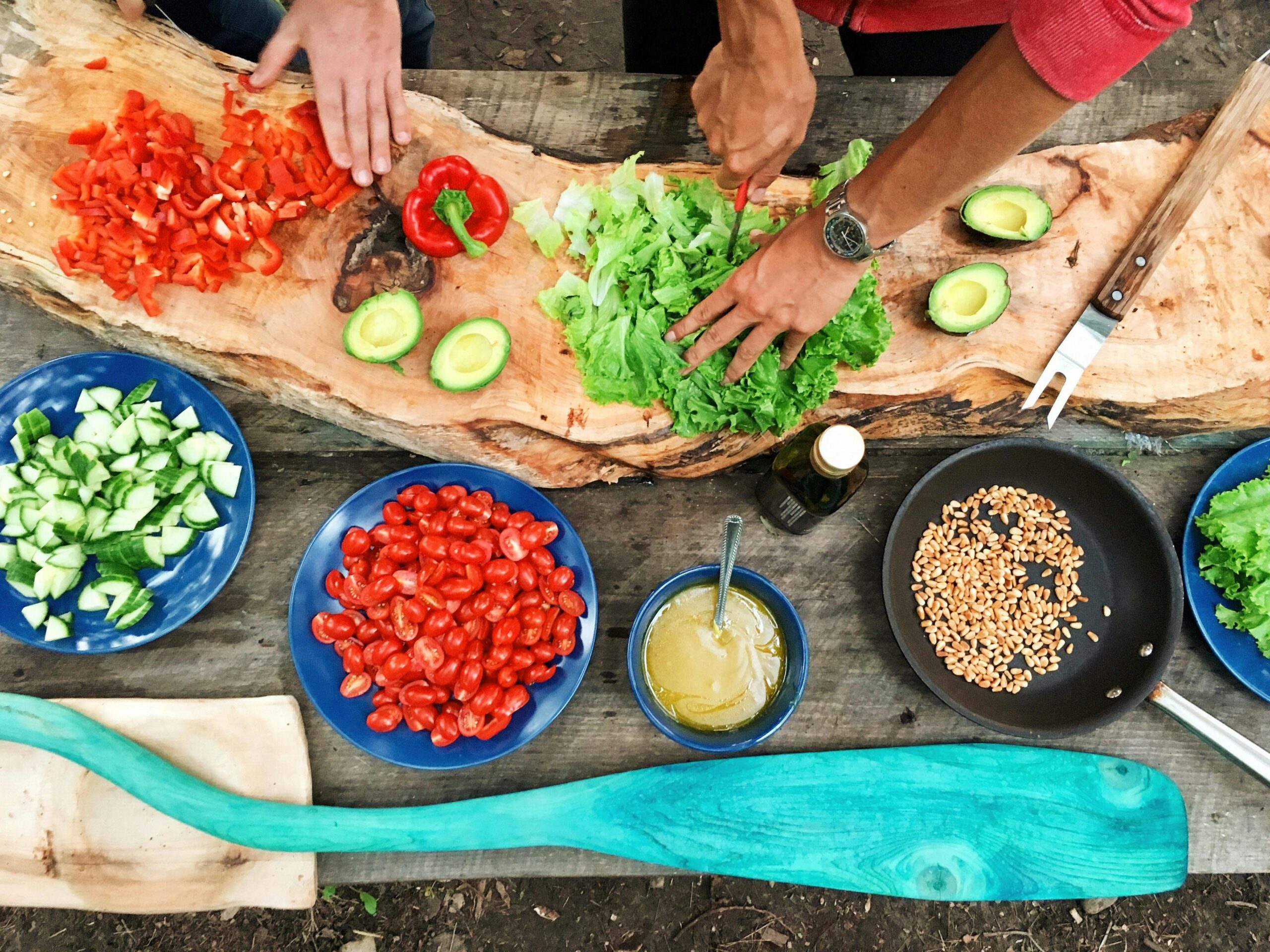 Fresh salad being prepped on a table in multiple dishes